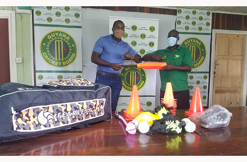 Chairman of the Special Development sub-committee for Essequibo’s cricket, Ryan Hercules (left), collects gear from  TDO of the GCB, Colin Stuart.