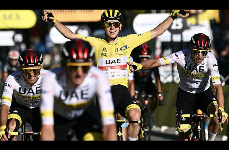 Winner team UAE Emirates' Tadej Pogacar (C) of Slovenia wearing the overall leader's yellow jersey celebrates with his teammates as he crosses the finish line at the end of last stage of the Tour de France cycling race on Sunaday. (AFP - ANNE-CHRISTINE POUJOULAT)