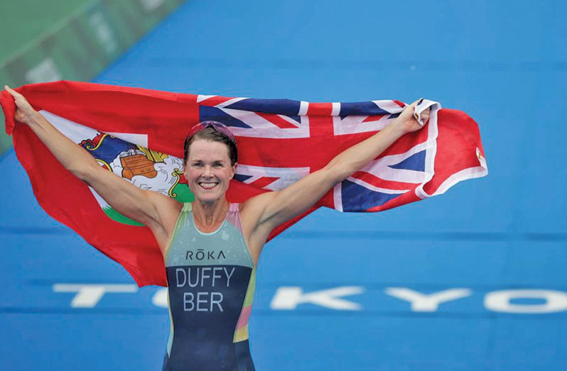 Tokyo 2020 Olympics - Triathlon - Women's Olympic Distance - Final - Odaiba Marine Park, Tokyo, Japan July 27, 2021. Flora Duffy of Bermuda holds national flag as she celebrates victory. REUTERS/Hannah Mckay