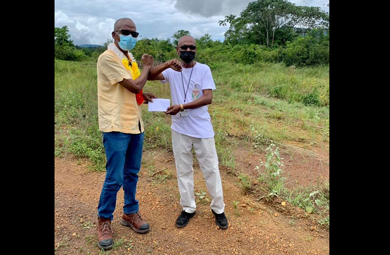 The official documents for the land being handed over to Labour Minister, Joseph Hamilton, by councillor, Rikhiram Ramphal of the Mahdia Town Council