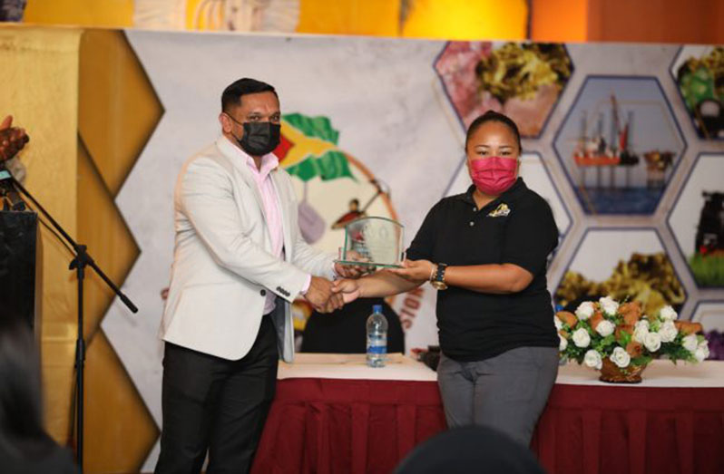 Minister of Natural Resources, Vickram Bharrat, presenting an award to a representative of S.A.B Mining