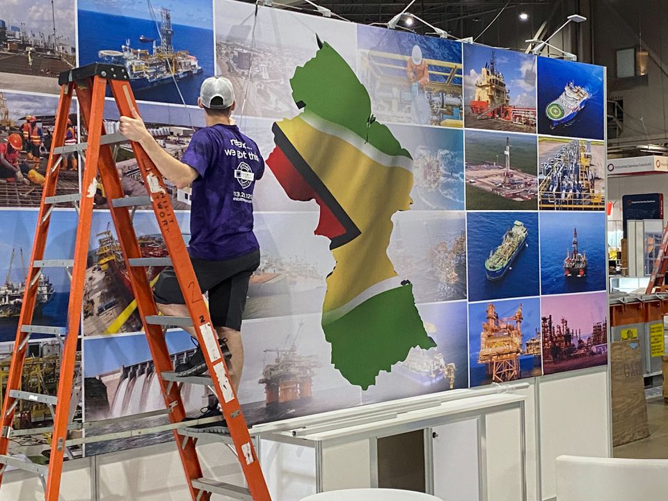 A worker puts finishing touches on exhibit booths at the Offshore Technology Conference in Houston, Texas, U.S., August 14, 2021 (REUTERS/Gary McWilliams)