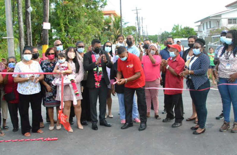 Minister within the Ministry of Public Works, Deodat Indar looks on as former Public Works Minister, Harrypersaud Nokta cuts the traditional ribbon to declare open Market Street, Industry