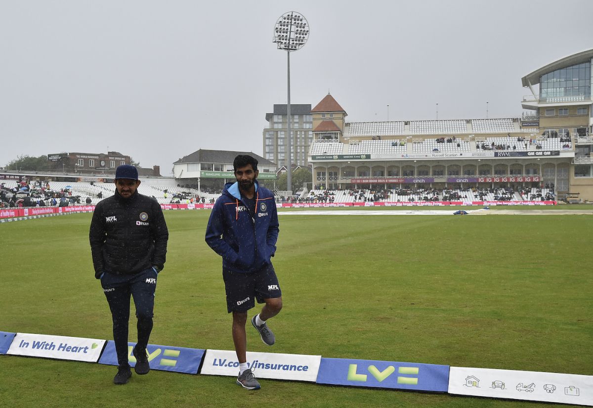 India's strength and conditioning coach, Soham Desai, and Jasprit Bumrah walk in the drizzle( England vs India, 1st Test, Nottingham, 5th day, August 8, 2021 © Associated Press)