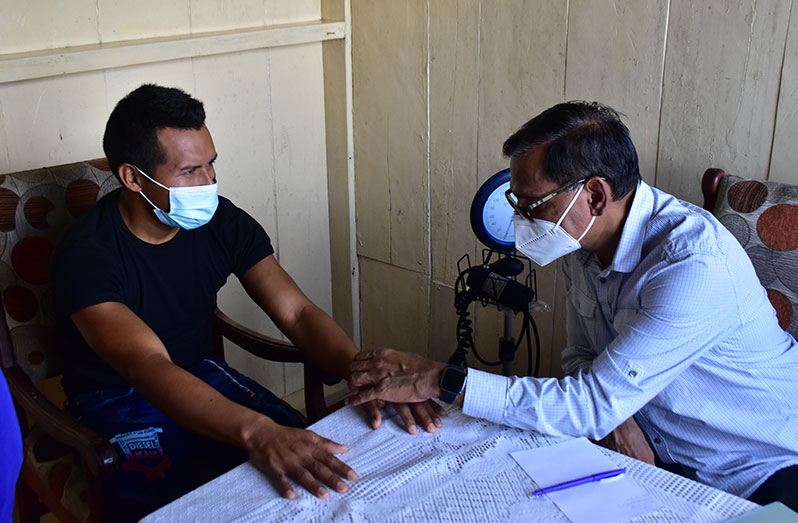 Director-General of the Ministry of Health, Dr. Vishwa Mahadeo, conducting a health checkup on a resident of Kaikan, in Region Seven (Cuyuni/Mazaruni), during the outreach on Friday (DPI photo)