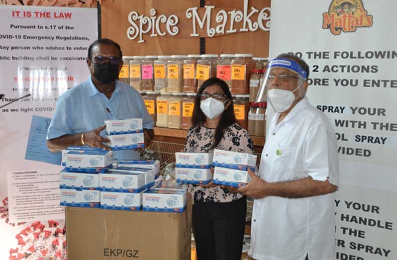 Minister within the Ministry of Local Government and Regional Development, Anand Persaud, receiving the masks from Bharati Mattai and Harry Mattai, owners of N & S Mattai’s Food Market, at their Georgetown location (DPI photo)