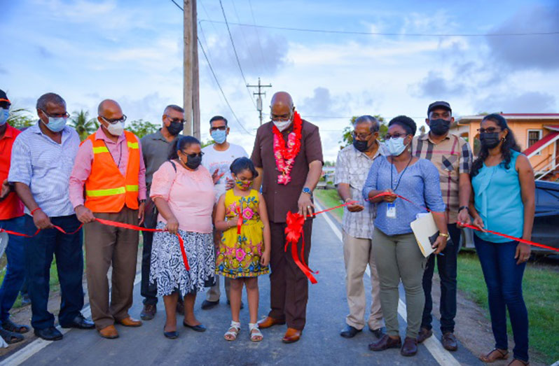Minister of Public Works, Bishop Juan Edghill, with the help of villagers, cuts the ceremonial ribbon to open Sari Dam