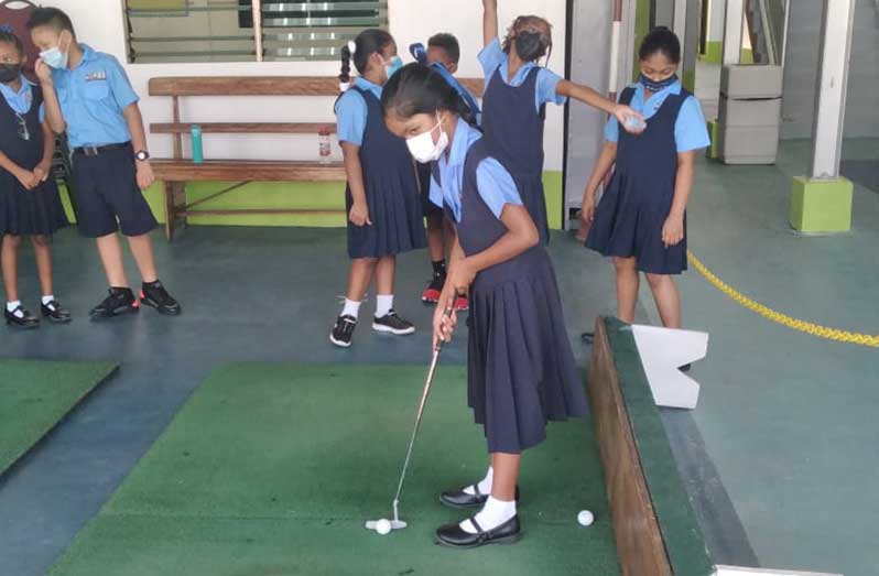 Some of the students of School of the Nations practicing their golf strokes