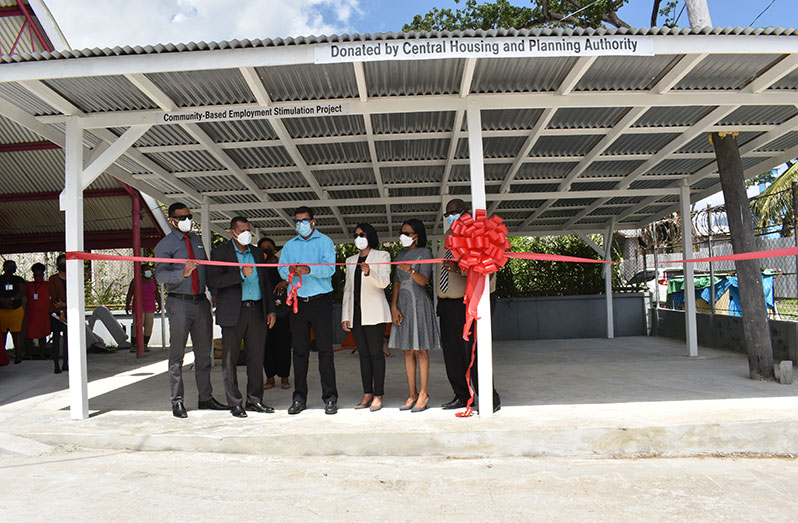 Programme Coordinator for the GCOPWD, Ganesh Singh, (centre) cuts the ceremonial ribbon to officially open the new block-making shed. Assisting him are Minister of Housing and Water, Colin Croal; Minister of Tourism Industry and Commerce, Oneidge Walrond, and CHPA CEO, Sherwyn Greaves (Elvin Croker photo)