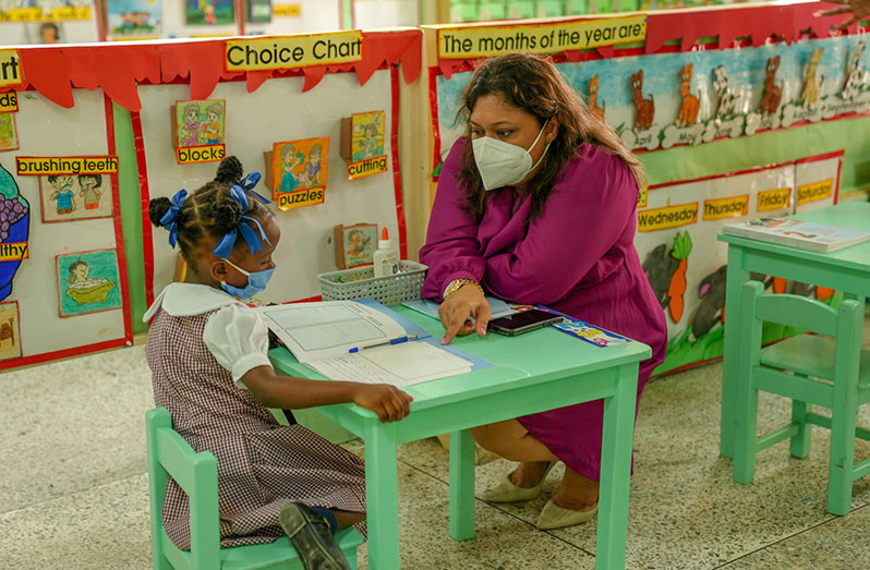 Minister of Education, Priya Manickchand, engages a nursery school child (MoE photo)