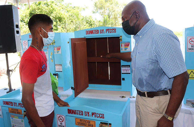 PTCCB Chairman, Dr. Leslie Munroe, explains the proper use of the storage cabinet to a young farmer who benefitted from the initiative