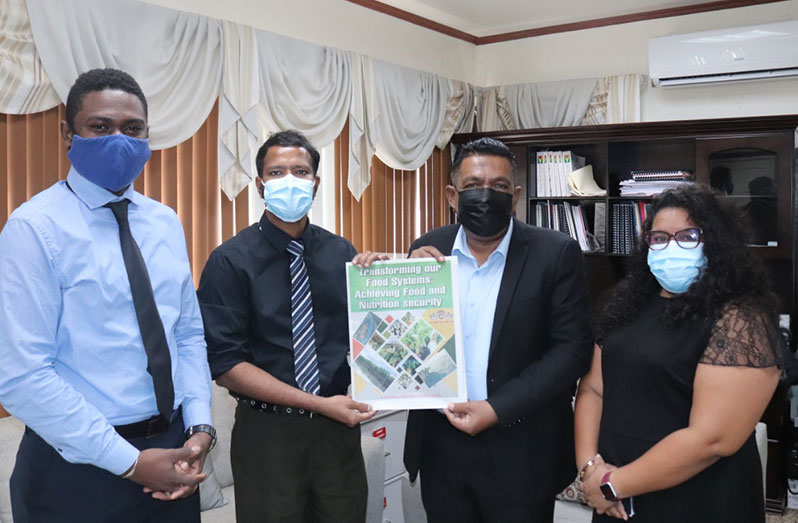 Minister of Agriculture, Zulfikar Mustapha (centre right) receives a copy of the Agriculture Month 2021 supplement from Editor-in-Chief, Tajeram Mohabir (centre left); flanked by Online Editor, Derwayne Wills (left); and Chief Reporter, Rehana Ahamad (right)