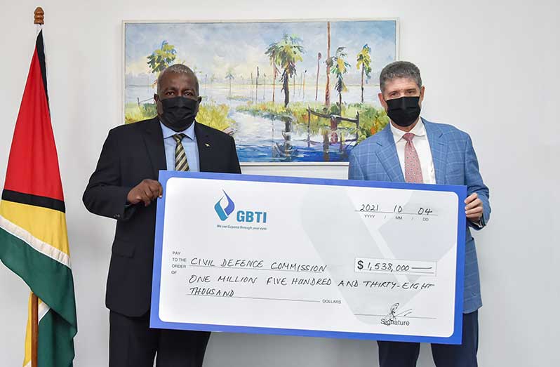 Acting President, Brigadier (Ret’d), Mark Phillips, receives the cheque from GBTI’s Chief Executive Officer (ag), James Foster (Office of the Prime Minister photo)