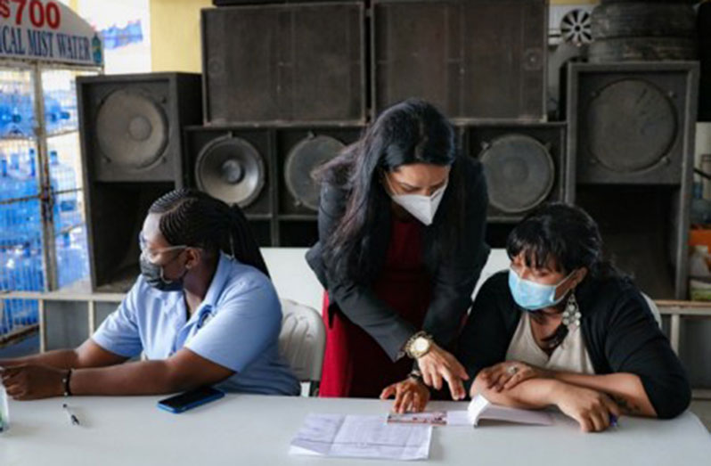 Human Services and Social Security Minister, Dr. Vindyha Persaud, assisting pension distributors at the Sukhpaul’s Gas Station, Region Six (DPI photo)