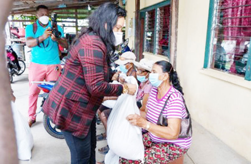 Human Services and Social Security Minister, Dr. Vindhya Persaud, handing a food hamper to a senior citizen at the Wakenaam Neighbourhood Democratic Council, Region Three