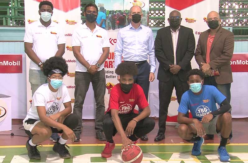 Alistair Routledge, President of ExxonMobil Guyana (centre) along with Director Sport, Steve Ninvalle (second from right) along with Rayad Boyce, Co-Director of YBG (second from left), and other officials and players at the Cliff Anderson Sports Hall on Friday