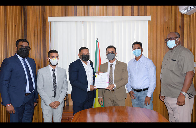 Minister of Natural Resources, Vickram Bharrat presents the licence to Director of Kamaira Quarry, Lorenzo Alphonso in the presence of senior government and company officials (Delano Williams photo)