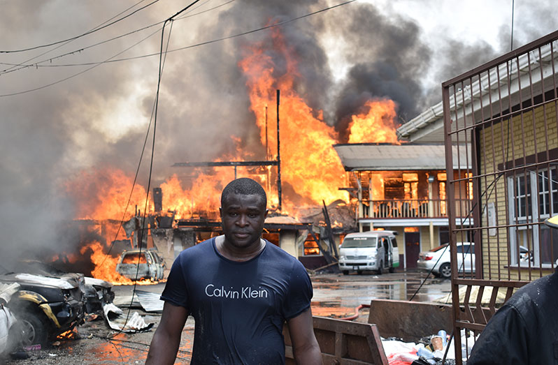 A member of the security forces at the scene of the Brickdam Police Station fire (Elvin Croker photo)