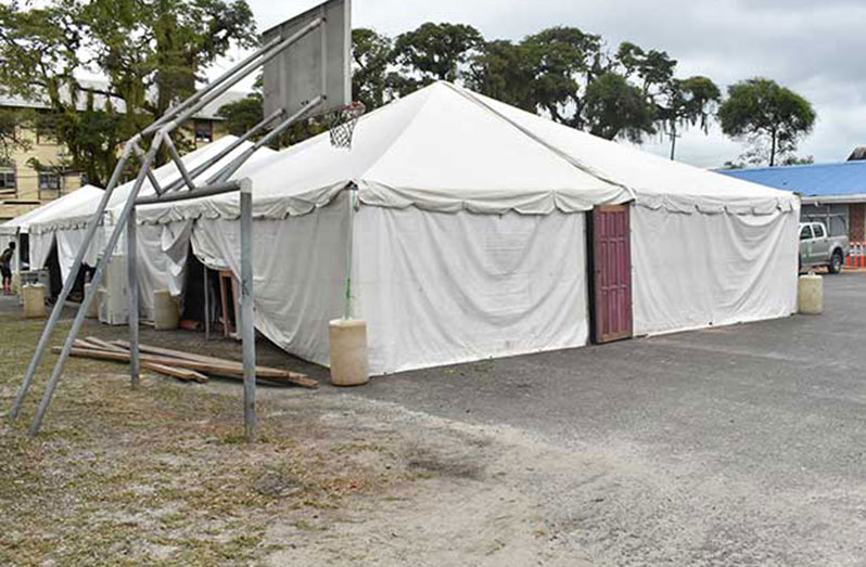 A section of the St. Stanislaus College tarmac where tents are set up to provide the services that were offered at the Brickdam Police Station before the fire (Elvin Croker photo)