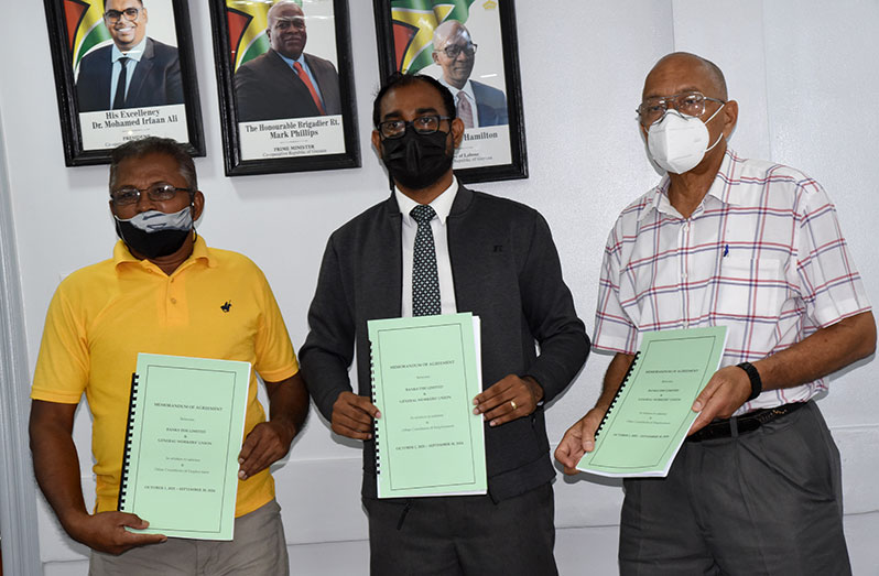 Chief Labour Officer, Dhaneshwar Deonarine (centre); Human Resources Director, Andrew Carto (right) and General-Secretary of the General Workers Union, Pancham Singh (left) display the MoA following the signing