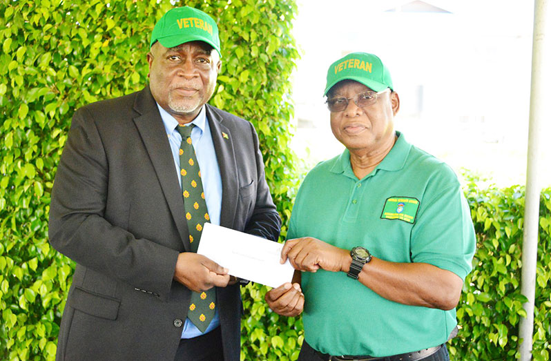 Prime Minister Brigadier (ret'd), Mark Phillips, presents a cheque to President of the Guyana Veterans Legion Lieutenant Colonel (ret'd) George Gomes