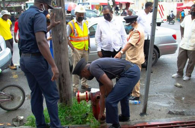 Minister within the Ministry of Local Government and Regional Development, Anand Persaud and Fire Chief, Kalamadeen Edoo, observe fire service ranks inspecting a city hydrant