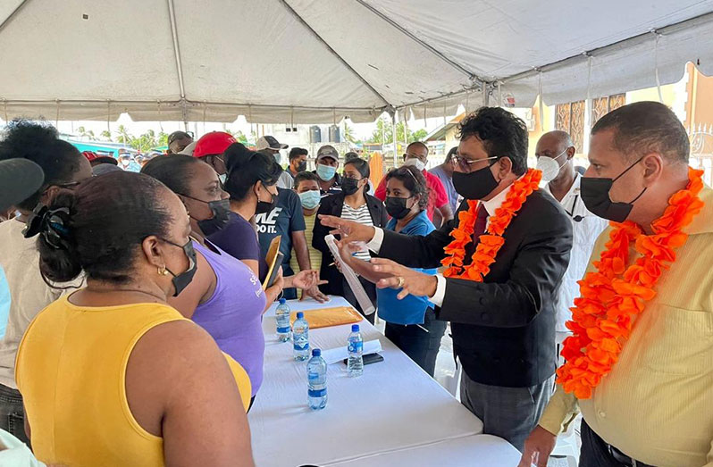 Attorney-General and Minister of Legal Affairs, Mohabir Anil Nandlall, SC (second right) and Housing and Water Minister, Collin Croal (right) interacting with Zeelugt residents