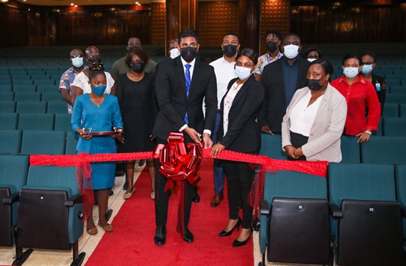 Minister of Culture, Youth and Sport Charles Ramson Jr. cuts the ceremonial ribbon to commission the new theatre seats at the NCC