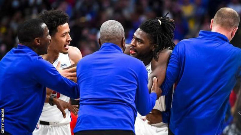 A bloodied Isaiah Stewart is held back by team-mates and coaching staff