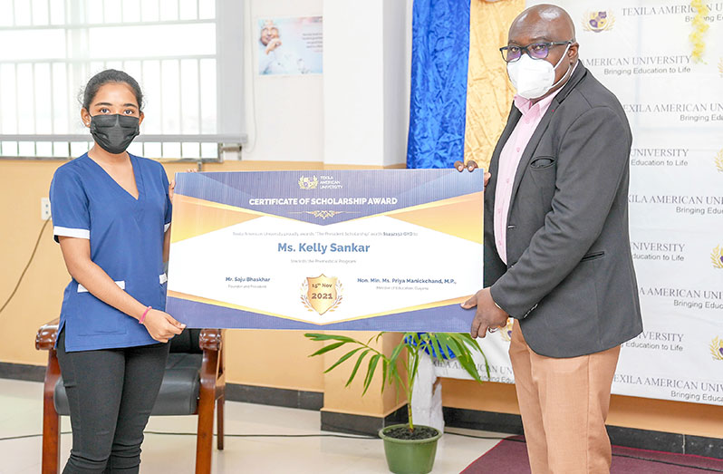 Chief Education Officer, Dr. Marcel Hutson presenting the scholarship award to Kelly Sankar