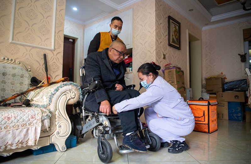 A senior receives care service at home in Chongqing, southwest China, Dec. 2, 2021 (Xinhua/Tang Yi)