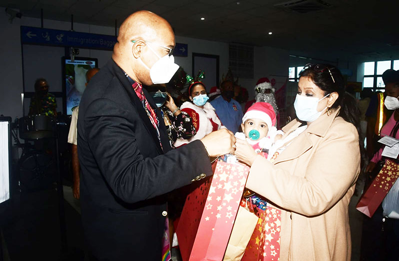 Minister of Public Works, Bishop Juan Edghill handing over one of the “goodies bags” to a returning Guyanese at the CJIA on Thursday