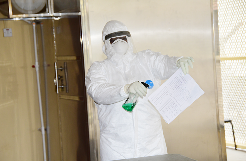 Health worker sterilises a document during a sanitisation exercise. (Adrian Narine/Guyana Chronicle)