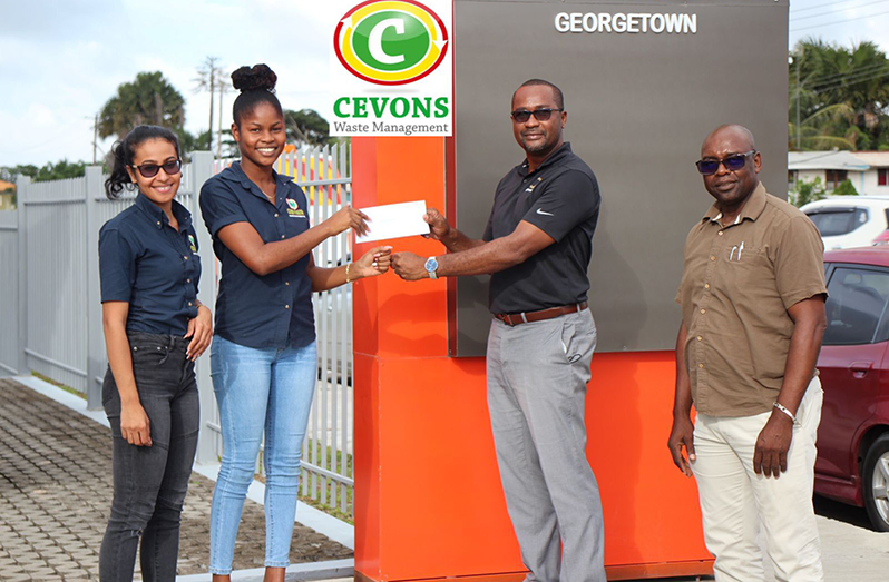Caption: Ms. Latoya Jacobs (2nd left) of Cevons Waste Management Inc. hands over sponsorship to GFF president Wayne Forde. At left is Jacobs’ colleague, Ms. Jennifer Gordon and at right is Aubrey ‘Shanghai’ Major