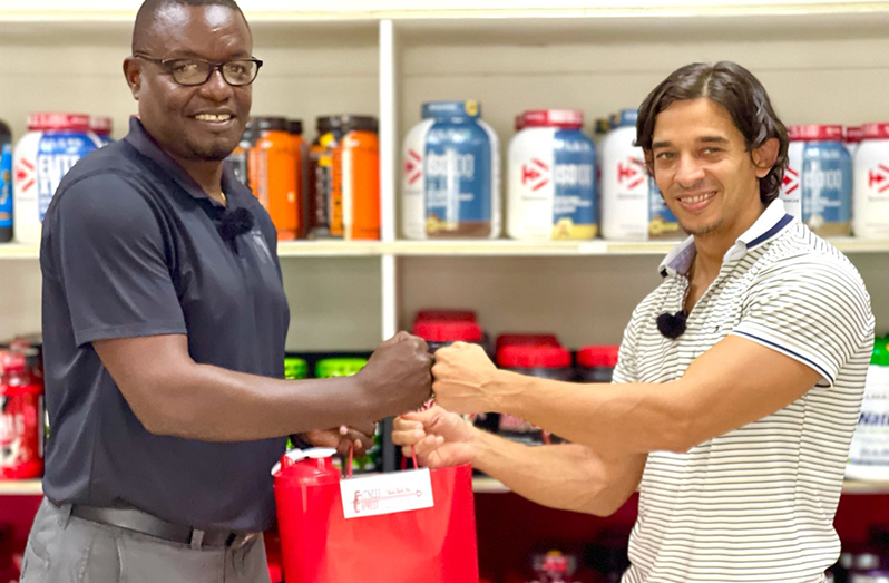 GFF Assistant Technical Director Bryan Joseph accepts hampers containing fitness products from Fitness Express owner, Jamie McDonald, to support the GFF's year-end tournaments