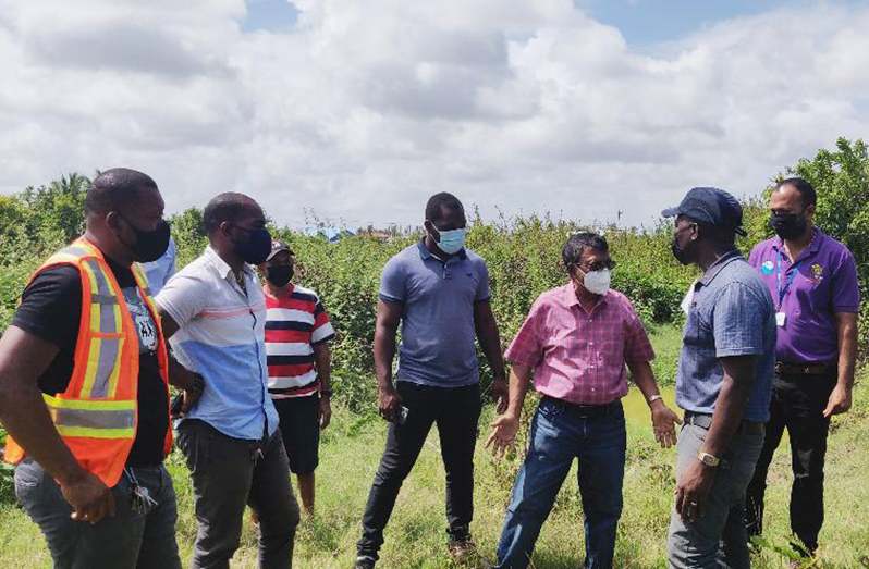 GWI CEO, Shaik Baksh, and other technical officials, along with an NDC representative, survey a plot of land in Chesney, Berbice 