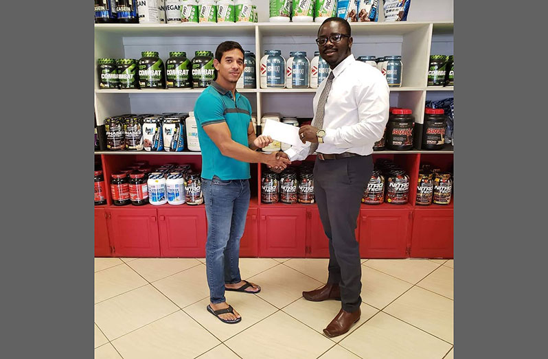 CEO of Fitness Express, Jamie McDonald, (left), a longtime supporter of bodybuilding, hands over the sponsorship cheque to GBBFF president Keavon Bess