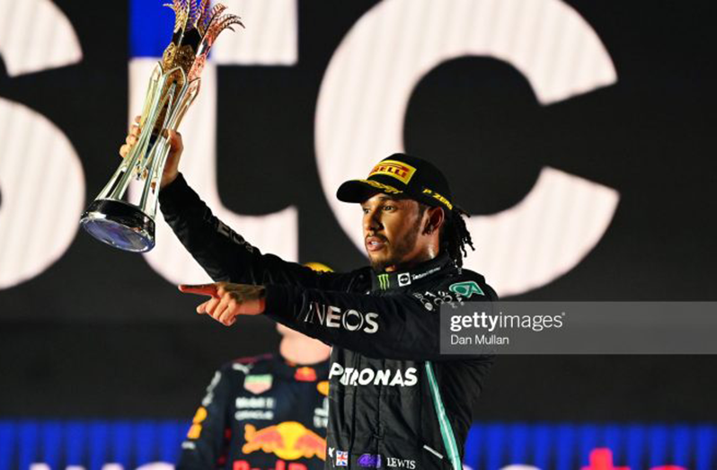 Race winner Lewis Hamilton of Great Britain and Mercedes GP celebrate on the podium during the F1 Grand Prix of Saudi Arabia at Jeddah Corniche Circuit on December 05, 2021 in Jeddah, Saudi Arabia. (Photo by Dan Mullan/Getty Images)