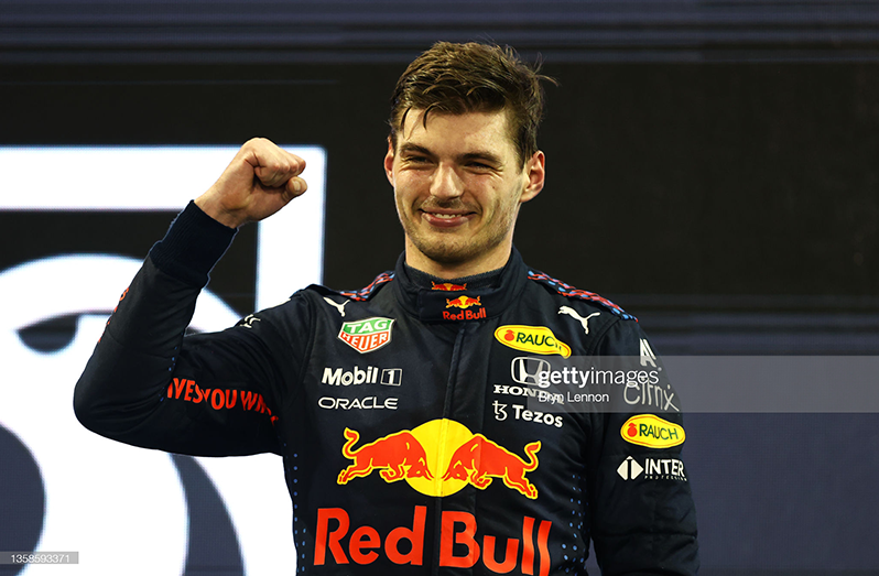 ABU DHABI, UNITED ARAB EMIRATES - DECEMBER 12: Race winner and 2021 F1 World Drivers Champion Max Verstappen of Netherlands and Red Bull Racing celebrates on the podium during the F1 Grand Prix of Abu Dhabi at Yas Marina Circuit on December 12, 2021 in Abu Dhabi, United Arab Emirates. (Photo by Bryn Lennon/Getty Images)