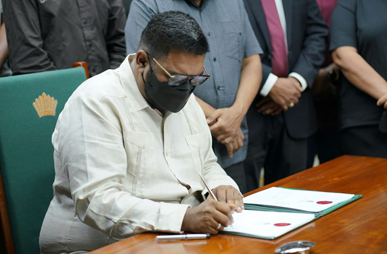 President Dr. Irfaan Ali signing the historic Local Content Act 2021 into law (Office of the President Photo)