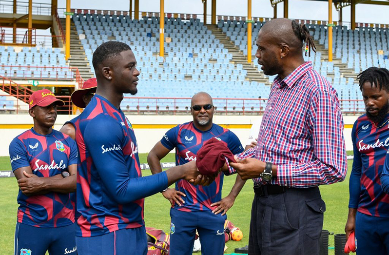 Jayden Seales (left) of West Indies receives his debut cap from former fast bowler Sir Curtly Ambrose at the start of Day One of the 1st Test vs South Africa at Darren Sammy Cricket Ground, Gros Islet, St Lucia, on June 10, 2021. (Photo by Randy Brooks/AFP)