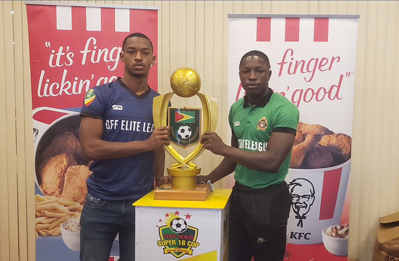 Western Tigers FC captain Curtez Kellman (left) and Guyana Defence Force captain, Sherwyn Caesar, hold the championship trophy at KFC on Friday
