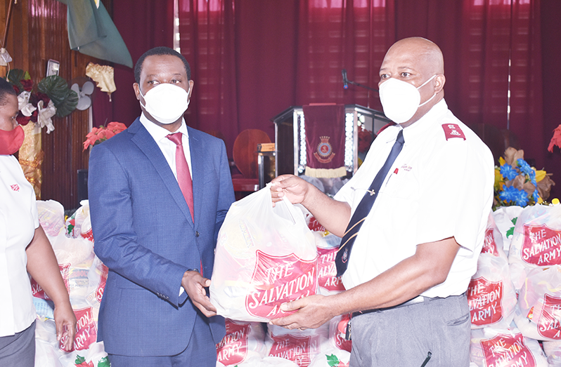 Minister Hugh Todd and Major Matignol Saint-Lot, the Divisional Commander of the Salvation Army, hold one of the hampers