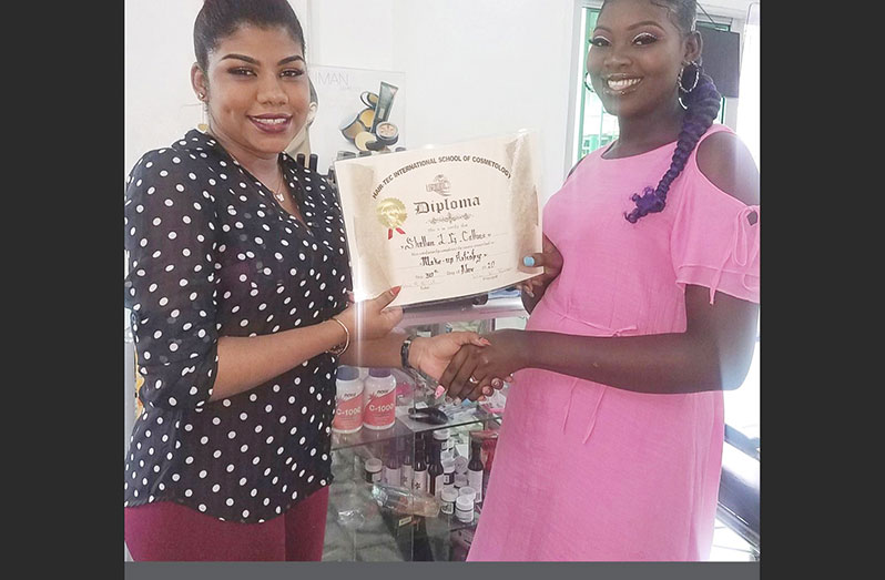 Kelisa (left) presents a certificate of participation to Shellon Collins, a student of the Hair Tech’s make-up artistry course