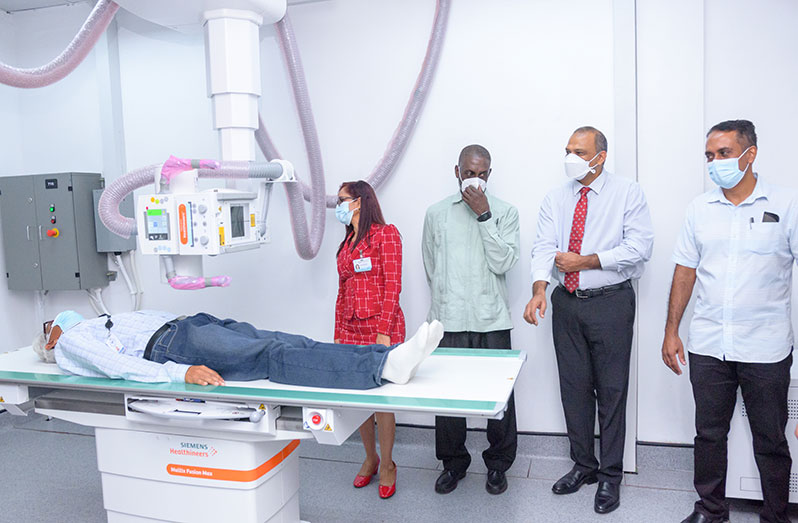 Minister of Health, Dr. Frank Anthony (second from right), and officials from the Georgetown Public Hospital (GPHC) look on at an employee trying out one of the fixed ceiling mounted x-ray machines (Photo: Delano Williams)