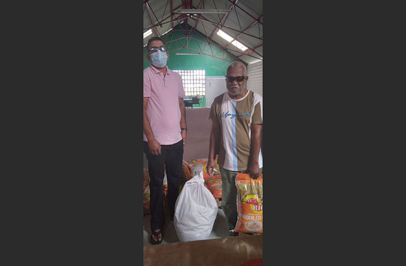 Programme co-ordinator, Ganesh Singh, (left) handing out hampers to Guyana Society for the Blind President, Cecil Morris