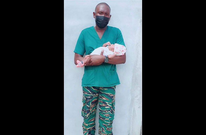 Corporal Dominique Gonsalves-Sabola with the newborn he delivered in November 2021