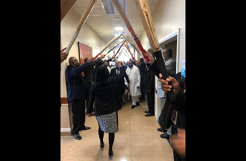 Present and former cricketers plus well wishers form a bat arch to pay their last respects to Jadunauth.