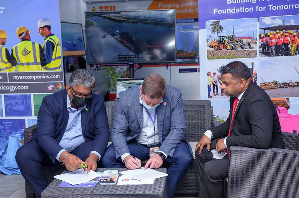 GAICO CEO, Komal Singh, (left) and Rev1 Energy CEO, Ricky Ehrgott (centre) sign the MoU as Minister within the Ministry of Public Works, Deodat Indar, looks on (Delano Williams photo)
