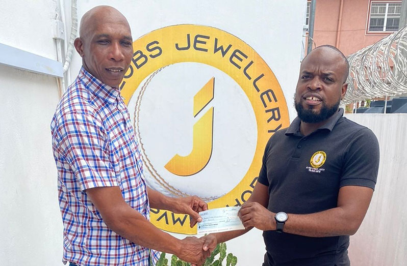 Shaun Massiah (left), GCA’s Competitions Committee Chairman, receives the cheque from Jemel Semple on behalf of Jacobs Jewellery and Pawn Shop
